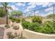 Beautiful backyard featuring tiered landscaping, desert landscape, and a wrought iron fence for added privacy at 6388 W Donald Dr, Glendale, AZ 85310