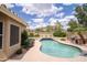 The backyard features a refreshing pool, surrounded by mature landscaping and a built-in barbecue grill at 6388 W Donald Dr, Glendale, AZ 85310
