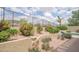 Relaxing backyard featuring mature landscaping, a desert aesthetic, and a secure wrought iron fence at 6388 W Donald Dr, Glendale, AZ 85310