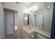 Well-lit bathroom with a vanity, toilet, mirror, and a glimpse into an adjacent room at 6388 W Donald Dr, Glendale, AZ 85310