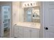 Bright bathroom featuring a large mirror, white vanity, and walk-in closet, providing functionality and style at 6388 W Donald Dr, Glendale, AZ 85310