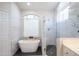 Bright bathroom with white cabinets, glass shower, and stand alone tub at 6388 W Donald Dr, Glendale, AZ 85310