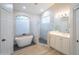 Bright bathroom with white cabinets, glass shower, and modern stand alone tub at 6388 W Donald Dr, Glendale, AZ 85310