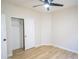 Well-lit bedroom with wood-look flooring, ceiling fan, and a closet with sliding doors, offering comfort and convenience at 6388 W Donald Dr, Glendale, AZ 85310