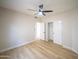 Bright bedroom with wood-look flooring, ceiling fan, and an open door to closet, perfect for relaxation and comfort at 6388 W Donald Dr, Glendale, AZ 85310