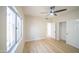 Comfortable bedroom features light, wood-look flooring, a ceiling fan, and a large window for natural light at 6388 W Donald Dr, Glendale, AZ 85310