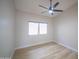 Simple bedroom with a window, fan, wood-look floors, and neutral colored walls at 6388 W Donald Dr, Glendale, AZ 85310