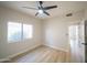 Inviting bedroom featuring wood-look flooring, ceiling fan, and bright window for natural light at 6388 W Donald Dr, Glendale, AZ 85310