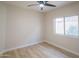 Clean and modern bedroom with wood-look flooring, ceiling fan, and ample natural light from a window at 6388 W Donald Dr, Glendale, AZ 85310
