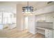 Bright dining area with modern light fixture, built-in desk with granite counters, and an open-concept view to the kitchen at 6388 W Donald Dr, Glendale, AZ 85310