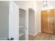 Bright foyer showcasing a wood door, an arched entryway, and an open shelved linen closet with wood-look floors at 6388 W Donald Dr, Glendale, AZ 85310