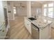 Bright kitchen featuring an island with a sink, granite countertops, stainless steel appliances, and light wood-look flooring at 6388 W Donald Dr, Glendale, AZ 85310