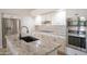 Kitchen boasts stainless steel appliances, granite countertops, white cabinets, and an island with a sink at 6388 W Donald Dr, Glendale, AZ 85310