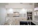 Well-lit kitchen with granite countertops, stainless steel appliances, white cabinets, and a stylish backsplash at 6388 W Donald Dr, Glendale, AZ 85310