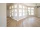 Bright and open living room features light wood-look flooring, corner windows, and backyard views at 6388 W Donald Dr, Glendale, AZ 85310