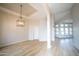 Spacious living room with wood-look floors, recessed ceiling and light fixture, leading to a sunlit seating area at 6388 W Donald Dr, Glendale, AZ 85310