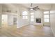 Open-concept living room with fireplace, a large ceiling fan, and views into a dining area and kitchen at 6388 W Donald Dr, Glendale, AZ 85310