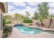 Desert-style pool with mature landscaping, a built in BBQ, and desert views for a peaceful outdoor experience at 6388 W Donald Dr, Glendale, AZ 85310