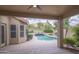 Relaxing view of a private backyard pool and spa from the covered patio with desert views and mature landscaping at 6388 W Donald Dr, Glendale, AZ 85310