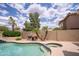 Relaxing backyard with a sparkling pool and spa, complemented by desert landscaping and a built-in barbecue at 6388 W Donald Dr, Glendale, AZ 85310