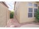View of the home's side yard featuring well-maintained gravel landscaping and mature shrubs at 6388 W Donald Dr, Glendale, AZ 85310