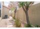 Side yard featuring a gravel path, blooming trees, and outdoor A/C unit at 6388 W Donald Dr, Glendale, AZ 85310