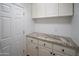 Utility room featuring white cabinets and granite countertops at 6388 W Donald Dr, Glendale, AZ 85310