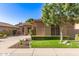Charming home featuring lush landscaping, verdant lawn, a stone accent wall, and a circular driveway at 712 W Jade Dr, Chandler, AZ 85248