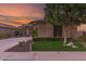 Charming home featuring lush landscaping, verdant lawn, a stone accent wall, and a circular driveway at 712 W Jade Dr, Chandler, AZ 85248