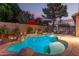 Outdoor pool area at dusk featuring a waterfall, palm trees, and overhead string lights for an ambient feel at 712 W Jade Dr, Chandler, AZ 85248