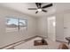 Bright bedroom featuring a ceiling fan, light wood floors and large window with neighborhood view at 7442 E Baseline Rd, Mesa, AZ 85209