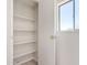 Hall closet with built in shelves and natural light from the window at 7442 E Baseline Rd, Mesa, AZ 85209