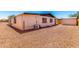 Exterior view of the home with gravel landscaping, an AC unit, and a fenced backyard at 7442 E Baseline Rd, Mesa, AZ 85209
