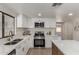 Modern kitchen with stainless steel appliances, quartz countertops, and a view to an adjacent room at 7442 E Baseline Rd, Mesa, AZ 85209