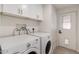 Functional laundry room features a modern washer and dryer set, with lots of storage and white cabinets at 7442 E Baseline Rd, Mesa, AZ 85209