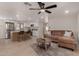 Inviting living room featuring a modern ceiling fan, plush sofa, and an open layout flowing into the kitchen at 7442 E Baseline Rd, Mesa, AZ 85209