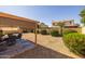 Backyard with covered patio, a gravel yard, manicured bushes, and block wall fencing at 8952 W Monte Vista Rd, Phoenix, AZ 85037