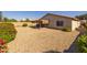 Spacious backyard with gravel, a covered patio area, and decorative landscaping at 8952 W Monte Vista Rd, Phoenix, AZ 85037