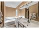 Bright bathroom featuring a soaking tub, dual sinks, and well-lit vanity area at 8952 W Monte Vista Rd, Phoenix, AZ 85037