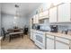 Functional kitchen featuring white appliances, tile floors, and an adjacent dining area at 8952 W Monte Vista Rd, Phoenix, AZ 85037