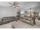 Open-concept living room featuring neutral-toned couches, ceiling fan, and access to the dining area at 8952 W Monte Vista Rd, Phoenix, AZ 85037