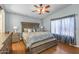 Cozy main bedroom with ceiling fan, complemented by hardwood floors and natural light at 8952 W Monte Vista Rd, Phoenix, AZ 85037