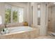 Elegant bathroom featuring travertine tile and a large jacuzzi tub overlooking a gorgeous landscape at 10531 E Cinder Cone Trl, Scottsdale, AZ 85262