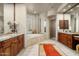 Expansive bathroom boasting dual vanities, a jacuzzi tub, travertine floors, and a glass enclosed shower at 10531 E Cinder Cone Trl, Scottsdale, AZ 85262