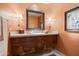 Elegant powder room featuring a custom vanity with decorative wood accents and a stone countertop at 10531 E Cinder Cone Trl, Scottsdale, AZ 85262