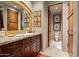 Well-lit bathroom featuring a granite countertop, wood cabinetry, and a decorative mirror at 10531 E Cinder Cone Trl, Scottsdale, AZ 85262