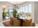 Dining area with expansive views of pool and backyard, complemented by a stylish chandelier and comfortable seating at 10531 E Cinder Cone Trl, Scottsdale, AZ 85262