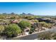 An aerial shot of a stunning desert home with a tile roof and beautiful desert landscaping at 10531 E Cinder Cone Trl, Scottsdale, AZ 85262