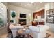 Cozy living room with fireplace, kitchenette, comfortable chairs and an entertainment center at 10531 E Cinder Cone Trl, Scottsdale, AZ 85262