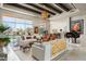 Open-concept living room with travertine floors, wood beams, and an inviting seating arrangement at 10531 E Cinder Cone Trl, Scottsdale, AZ 85262